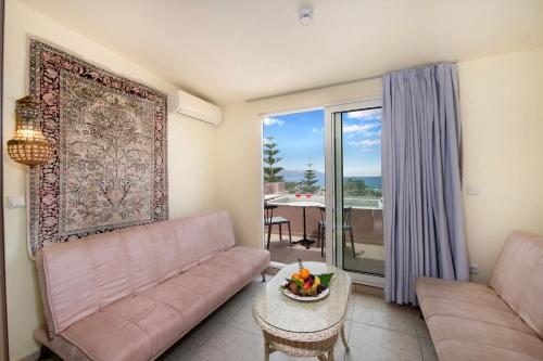 a living room with a couch and a table at Orpheas Resort Hotel (Adults Only) in Georgioupolis