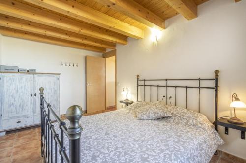 ein Schlafzimmer mit einem Bett in einem Zimmer mit Holzdecken in der Unterkunft El Refugi De Rubinat in Sant Antolí i Vilanova