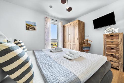 ein Schlafzimmer mit einem Bett mit zwei Handtüchern darauf in der Unterkunft Moby Dick in Olpenitz