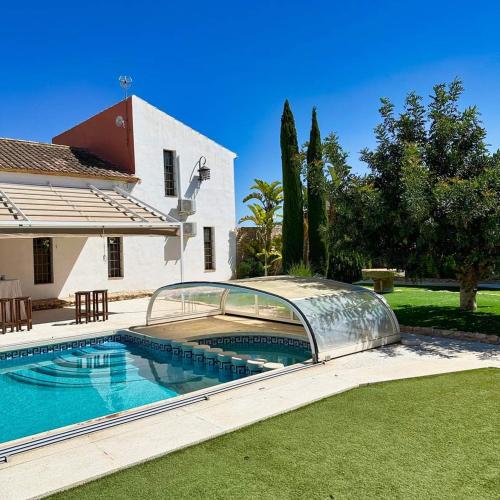 a swimming pool in front of a house at Casas Rurales Venta Seca complejo Rural para 24-28 plazass in Mazarrón