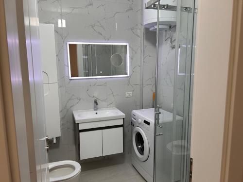 a bathroom with a toilet and a sink and a mirror at Dona Elegant Beach Apartment in Durrës