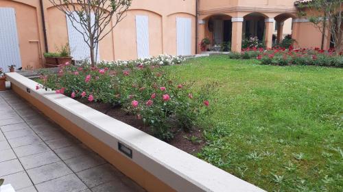um jardim com flores rosas e brancas num quintal em A Casa San Pietro - bilocale centro storico - Cyclist-friendly em Castel San Pietro Terme
