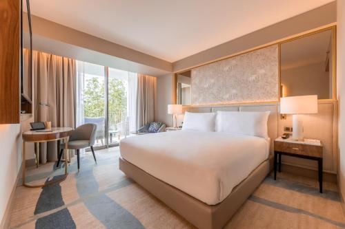 a hotel room with a bed and a desk and a room at Legacy Hotel Cascais, Curio Collection By Hilton in Cascais