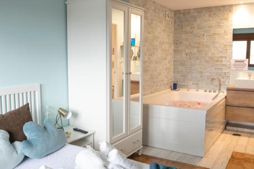uma casa de banho com banheira e uma cama num quarto em La Veiguela de Gijón II, con plaza de garaje incluida em Gijón