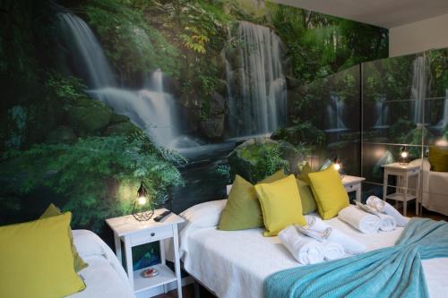 1 Schlafzimmer mit 2 Betten und einem Wasserfall-Wandbild in der Unterkunft La Veiguela de Gijón II, con plaza de garaje incluida in Gijón