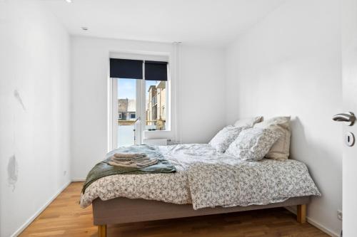 Schlafzimmer mit einem Bett und einem Fenster in der Unterkunft Moderne Lejlighed i Aalborg Vestby - 1 BR in Aalborg