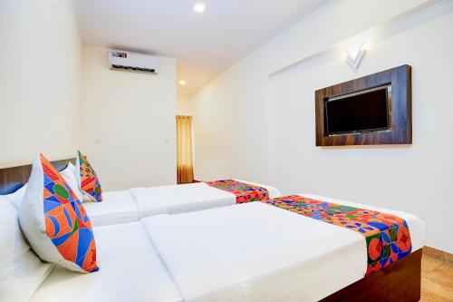 um quarto de hotel com duas camas e uma televisão em FabHotel GRK Comforts em Bangalore