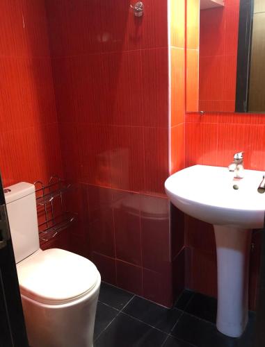 a bathroom with a white toilet and a sink at Cozy apartment in the city center in Tbilisi City