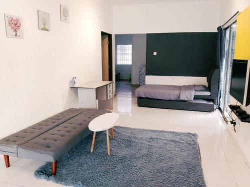 a bedroom with a bed and a bench and a table at Area Indahpura or Taman Bersatu Kulai 3-4BR near AEON Airport JPO in Kulai