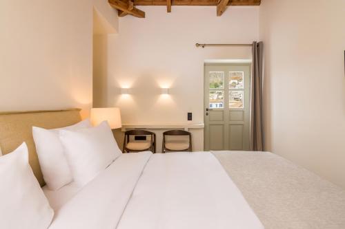 a bedroom with a large white bed with white pillows at Maison Muse in Hydra