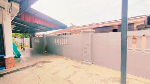 a fence in front of a building with a playground at Area Indahpura or Taman Bersatu Kulai 3-4BR near AEON Airport JPO in Kulai
