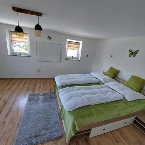 a bedroom with a large bed and two windows at Ferienparadies Haus Monica in Palting