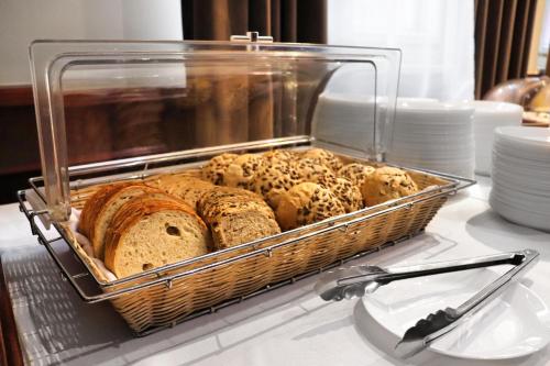 a basket of different types of bread on a table at Hotel Lothus in Wrocław