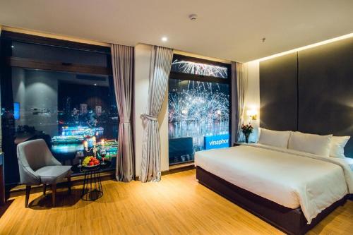 een hotelkamer met een bed en een groot raam bij Glamour Hotel Da Nang in Da Nang