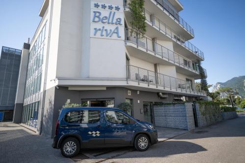 a blue car parked in front of a building at Hotel Bellariva in Riva del Garda