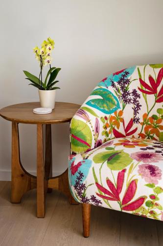 a chair sitting next to a wooden table with a plant at La Petite Ferme in Franschhoek