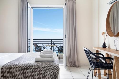 een slaapkamer met een bed en een balkon met uitzicht bij Sunset Premium Studio 8 in Ayios Nikitas