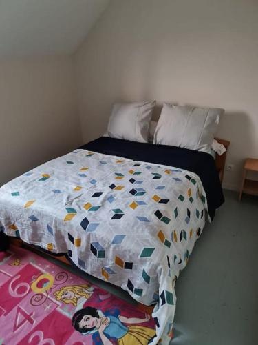 un lit avec une couette dessus dans une chambre dans l'établissement Excellent logis à Marcilly, à Marcilly-sur-Vienne