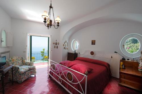 a bedroom with a red bed and a window at Villa Cala del Marò in Praiano