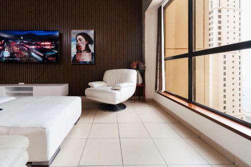 1 dormitorio con cama blanca, silla y ventana en SleepandGO, en Dubái