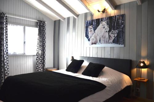 a bedroom with a black and white bed and a window at Chalet avec Jacuzzi, billard, jardin clos, proche Paradiski in Aime La Plagne