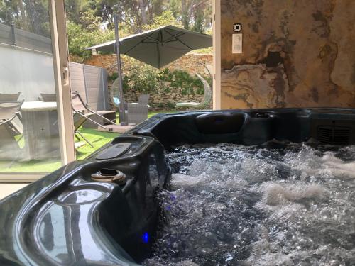 un toboggan aquatique dans une cour arrière avec un parasol dans l'établissement Etoiles de Provence PASSION, à La Ciotat