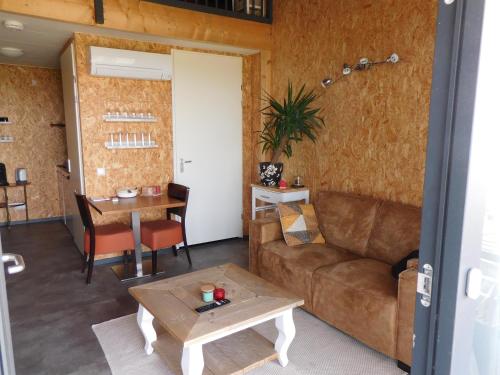 a living room with a couch and a table at Deel erf Het 8ste Werk in Kampen
