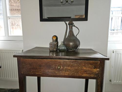 a table with a vase and other items on it at CASA LEONE BADALUCCO in Badalucco