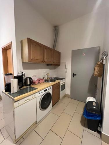 a kitchen with a refrigerator and a washing machine at Private Souterrain Apartment in the green of Berlin in Birkenwerder