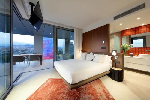 a bedroom with a large white bed and a kitchen at Hotel SB Glow 4 Sup in Barcelona