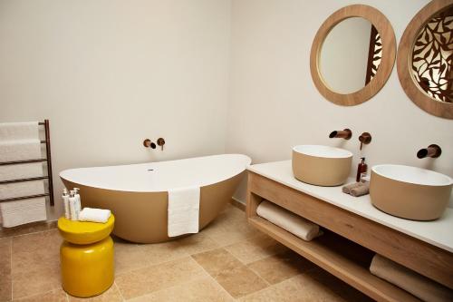 a bathroom with a large tub and a mirror at La Petite Ferme in Franschhoek
