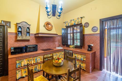 a kitchen with a table with a bowl of fruit on it at Casa rural Azahares de Marchena in Marchena
