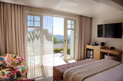 a hotel room with a bed and a sliding glass door at La Petite Ferme in Franschhoek