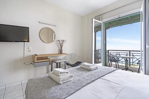 1 dormitorio con 1 cama, escritorio y balcón en Sunset Premium Studio 7, en Agios Nikitas