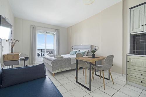 a bedroom with a bed and a table and chairs at Sunset Premium Studio 7 in Agios Nikitas