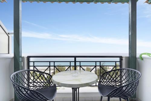a white table and two chairs on a balcony at Sunset Premium Studio 7 in Agios Nikitas