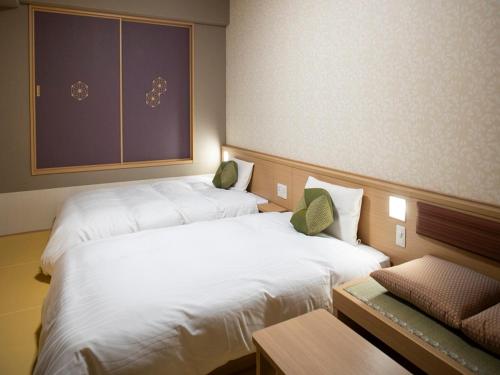 京都市にある天然温泉 蓮花の湯 御宿 野乃 京都七条 のベッド2台、テーブル、シドックスシドックスシドックスが備わる客室です。