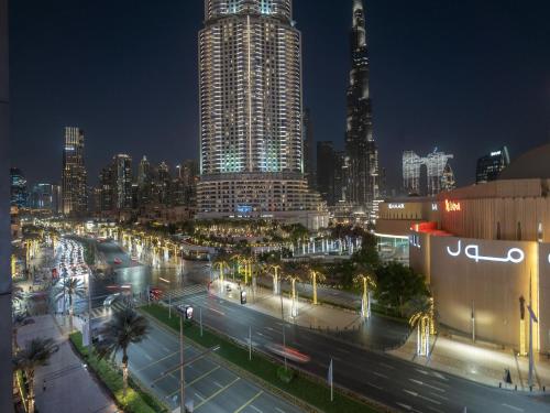 un skyline della città di notte con una strada trafficata di Luxurious Stylish Apartments Across Dubai Mall Burj Khalifa City Views a Dubai