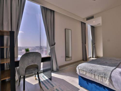 a hotel room with a bed and a desk and a window at Luxurious Apartments Dubai Marina Views Pool Gym by Sojo Stay in Dubai