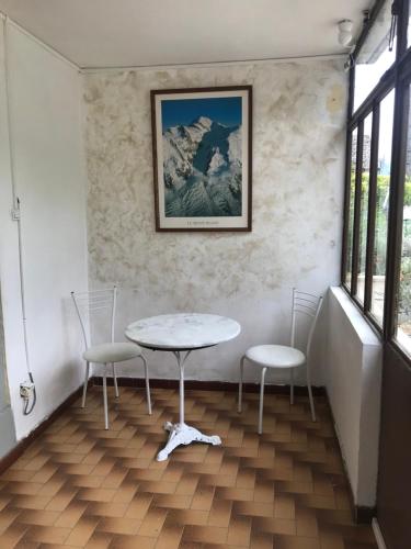 a table and chairs in a room with windows at Escale in La Motte-Servolex