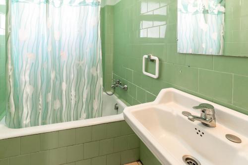 a bathroom with a sink and a shower curtain at La Farella 63 apartamento con terraza y vistas in Girona