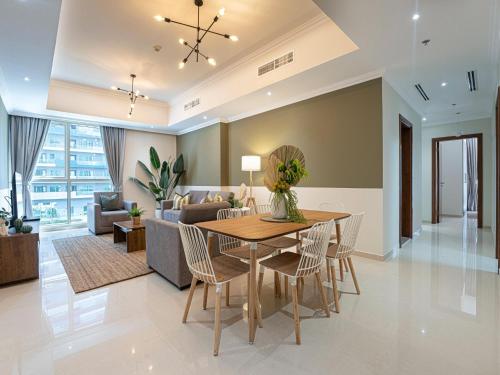 ein Esszimmer und ein Wohnzimmer mit einem Tisch und Stühlen in der Unterkunft Luxe Apartments near Dubai Mall Burj Khalifa Pool Gym Parking in Dubai