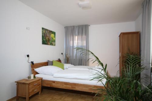 - une chambre dotée d'un lit avec des draps blancs dans l'établissement Der Teichhof, à Grandenborn