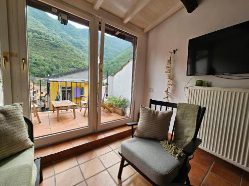 a living room with a large window and a television at CASA LEONE BADALUCCO in Badalucco