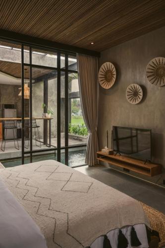a bedroom with a large bed and a kitchen at Danu Villas Bali in Kerobokan