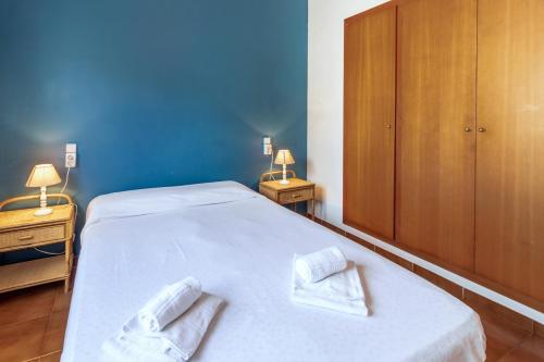 ein Schlafzimmer mit zwei weißen Handtüchern auf einem Bett in der Unterkunft La Farella-Coma 66 - Apartamento con piscina comm in Girona