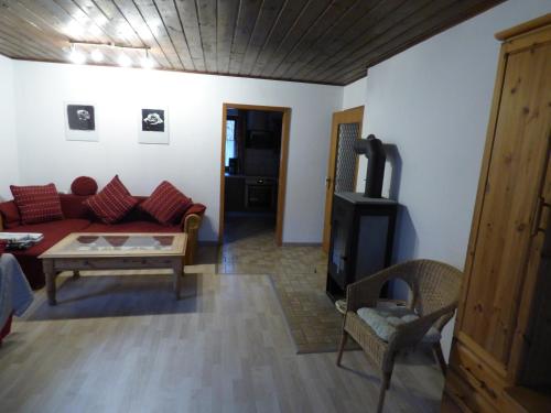 ein Wohnzimmer mit einem Sofa und einem Tisch in der Unterkunft Ferienwohnung Eurasburg im Loisachtal in Eurasburg