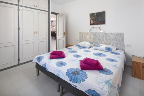 een slaapkamer met een bed met roze kussens erop bij Villa Mimosa in Cómpeta