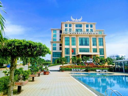 a hotel with a swimming pool in front of a building at Muong Thanh Holiday Ly Son in Ly Son