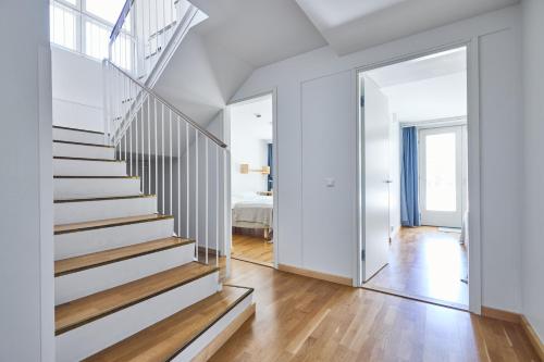 a white staircase in a white house with a mirror at Töölö Towers in Helsinki